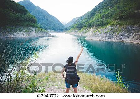 Stock Image - Tourist raising arm at Lake Garda, Italy. Fotosearch