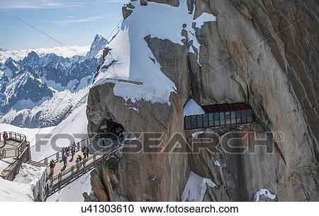 Stock Image -  Tourists crossing bridge at Aguille du Midi, Mont Blanc, Chamonix, Haute Savoie, France. Fotosearch