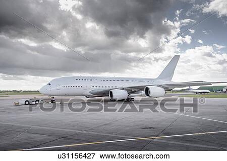 Stock Photo - Towing tug moving A380 aircraft onto runway. Fotosearch
