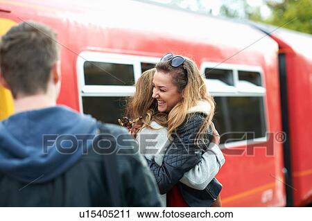 Two female friends hugging at railway station, smiling View Large Photo Image Stock Image - Two female friends hugging at railway station, smiling. Fotosearch