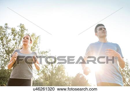 Two young adults, running through field View Large Photo Image Stock Image - Two young adults, running through field. Fotosearch