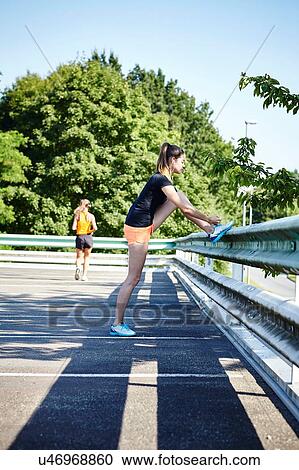 Stock Image - Two young female runners training in parking lot. Fotosearch