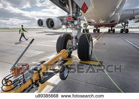 Underside view of A380 aircraft attached to towing tug View Large Photo Image Stock Photo - Underside view of A380 aircraft attached to towing tug. Fotosearch