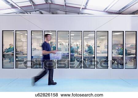 Stock Photo - View of workers in clean room in surgical instrument factory. Fotosearch