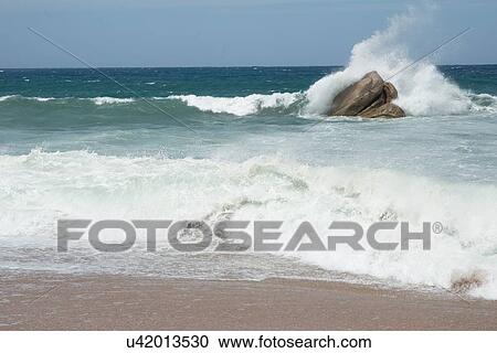 Stock Image - Wave crashing against rocks in ocean, Castelsardo, Sardinia, Italy. Fotosearch