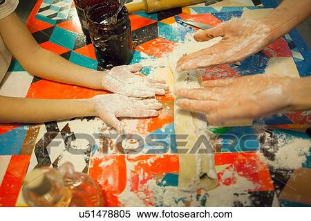 Woman and son comparing messy floured hands at kitchen table View Large Photo Image Stock Photography - Woman and son comparing messy floured hands at kitchen table. Fotosearch
