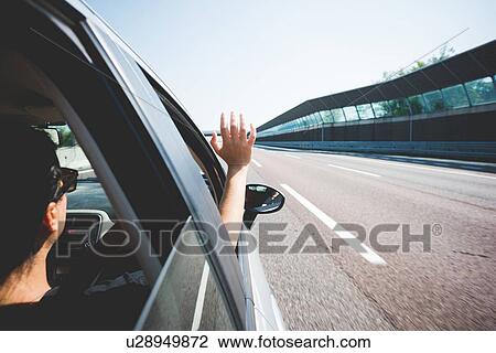 Stock Image - Woman travelling on highway, Garda, Italy. Fotosearch