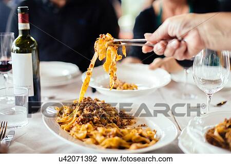 Womans hand serving tagliatelle with ragu sauce at table View Large Photo Image Stock Image - Womans hand serving tagliatelle with ragu sauce at table. Fotosearch