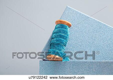 Wooden reel of sparkly blue ribbon on top of gift box View Large Photo Image Stock Image - Wooden reel of sparkly blue ribbon on top of gift box. Fotosearch