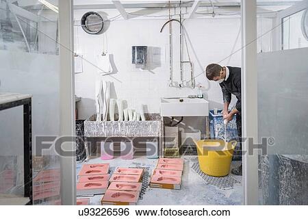 Worker casting plaster into foot moulds for orthopaedic support in factory View Large Photo Image Stock Photograph - Worker casting plaster into foot moulds for orthopaedic support in factory. Fotosearch