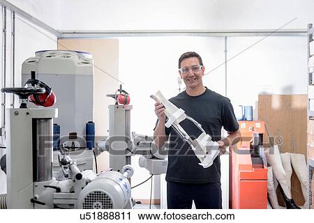 Worker holding orthopaedic support in medical factory, portrait View Large Photo Image Stock Image - Worker holding orthopaedic support in medical factory, portrait. Fotosearch