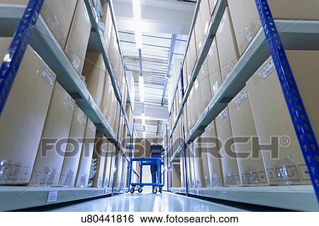 Stock Photograph - Worker in warehouse of surgical instruments factory. Fotosearch