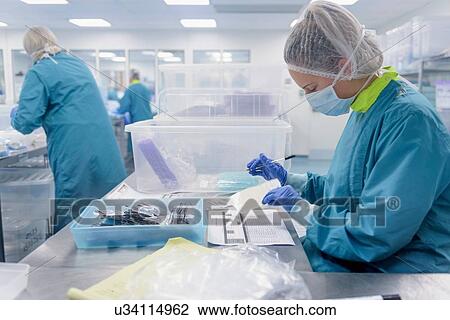 Worker making notes in clean room of surgical instruments factory View Large Photo Image Stock Image - Worker making notes in clean room of surgical instruments factory. Fotosearch