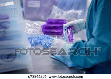 Stock Photography - Worker packing surgical instruments in clean room of surgical instruments factory, close up. Fotosearch