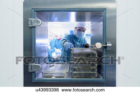 Worker putting surgical instruments into air lock in clean room of surgical instruments factory View Large Photo Image Stock Photo - Worker putting surgical instruments into air lock in clean room of surgical instruments factory. Fotosearch