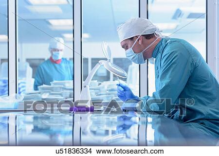 Picture - Workers inspecting surgical instruments in clean room of surgical instruments factory. Fotosearch