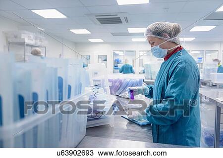 Stock Image - Workers pack surgical instruments in clean room of surgical instruments factory. Fotosearch