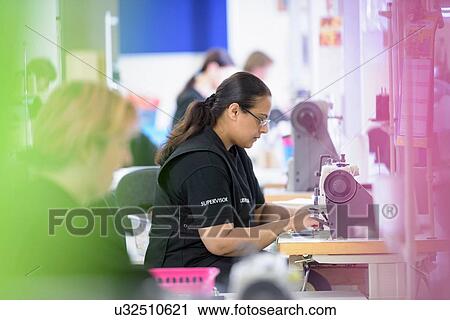 Stock Image - Workers sewing orthopaedic garments in factory. Fotosearch