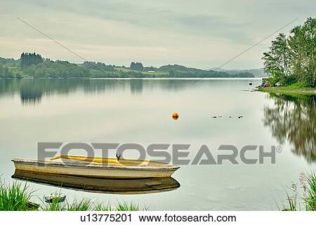 Stock Image - Yellow boat on fjord distant village, Vigdarvatnet, Norway. Fotosearch