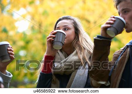 Young adult friends drinking takeaway coffee in autumn park View Large Photo Image Stock Image - Young adult friends drinking takeaway coffee in autumn park. Fotosearch
