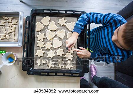 Stock Image - Young boy making cookies, overhead view. Fotosearch