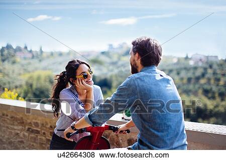 Young couple chatting on moped in Florence hills, Italy View Large Photo Image Stock Photo - Young couple chatting on moped in Florence hills, Italy. Fotosearch