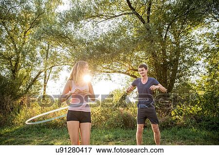 Young couple in rural environment, using hula hoops View Large Photo Image Stock Photo - Young couple in rural environment, using hula hoops. Fotosearch
