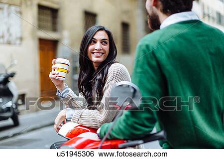 Young couple leaning on moped with takeaway coffee, Florence, Italy View Large Photo Image Stock Photograph - Young couple leaning on moped with takeaway coffee, Florence, Italy. Fotosearch