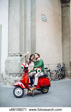Young couple on moped posing for smartphone selfie, Florence, Italy View Large Photo Image Stock Image - Young couple on moped posing for smartphone selfie, Florence, Italy. Fotosearch