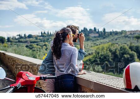 Stock Photography - Young couple photographing view of hills, Florence, Italy. Fotosearch