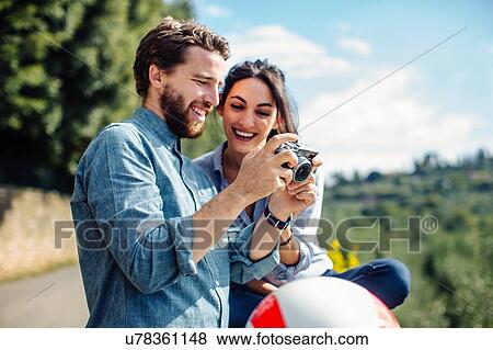 Stock Photo - Young couple reviewing photographs on digital camera, Florence, Italy. Fotosearch