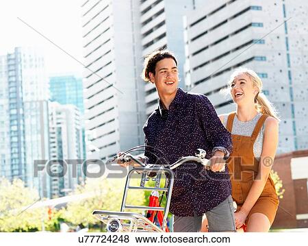 Young couple riding bicycle, Southbank, Melbourne, Australia View Large Photo Image Stock Photo - Young couple riding bicycle, Southbank, Melbourne, Australia. Fotosearch