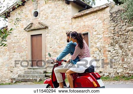 Young couple riding moped in village, Florence, Italy View Large Photo Image Picture - Young couple riding moped in village, Florence, Italy. Fotosearch