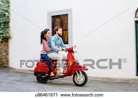 Young couple riding moped on village road, Florence, Italy View Large Photo Image Stock Image - Young couple riding moped on village road, Florence, Italy. Fotosearch