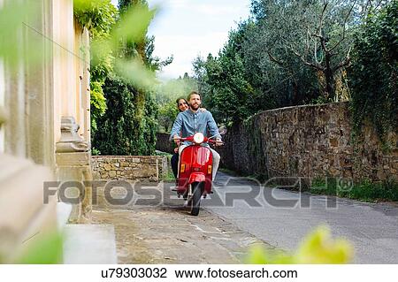 Young couple riding moped through village, Florence, Italy View Large Photo Image Stock Image - Young couple riding moped through village, Florence, Italy. Fotosearch
