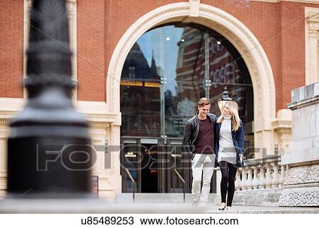 Stock Image - Young couple strolling outside Albert Hall, London, England, UK. Fotosearch