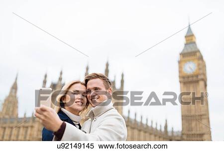 Young couple taking smartphone selfie in front of Big Ben, London, England, UK View Large Photo Image Stock Photography - Young couple taking smartphone selfie in front of Big Ben, London, England, UK. Fotosearch