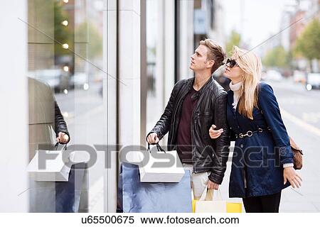 Stock Photography - Young couple window shopping, London, England, UK. Fotosearch