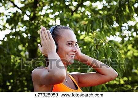Young female runner adjusting headphones View Large Photo Image Stock Photo - Young female runner adjusting headphones. Fotosearch