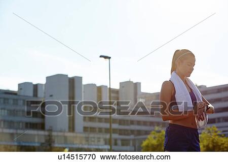 Young female runner checking smartwatch on urban rooftop View Large Photo Image Stock Image - Young female runner checking smartwatch on urban rooftop. Fotosearch