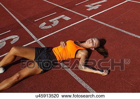 Young female runner lying on back exhausted on race track View Large Photo Image Stock Image - Young female runner lying on back exhausted on race track. Fotosearch