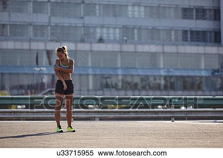 Young female runner selecting earphone music on urban rooftop View Large Photo Image Stock Photography - Young female runner selecting earphone music on urban rooftop. Fotosearch