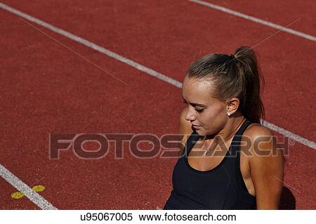 Young female runner sitting on race track View Large Photo Image Stock Photography - Young female runner sitting on race track. Fotosearch