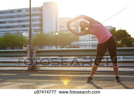 Young female runner warming up on rooftop View Large Photo Image Stock Photo - Young female runner warming up on rooftop. Fotosearch