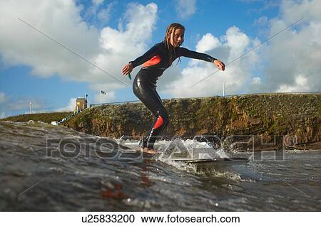 Young female surfer riding wave View Large Photo Image Stock Image - Young female surfer riding wave. Fotosearch