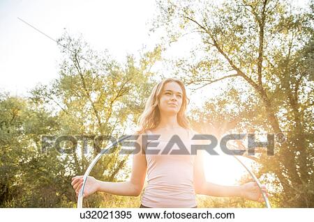 Stock Photography - Young girl in rural environment, holding hula hoop. Fotosearch