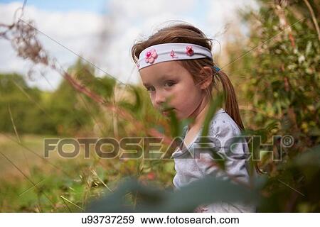 Young girl in rural setting, exploring View Large Photo Image Stock Photo - Young girl in rural setting, exploring. Fotosearch