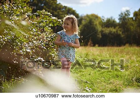 Young girl walking through field View Large Photo Image Stock Photo - Young girl walking through field. Fotosearch