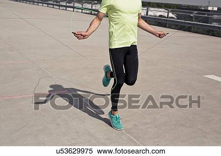 Stock Photography - Young man doing skipping training in city. Fotosearch