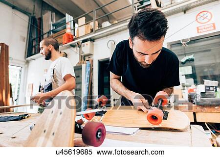 Young man in carpentry workshop attaching wheels to skateboard View Large Photo Image Stock Photography - Young man in carpentry workshop attaching wheels to skateboard. Fotosearch